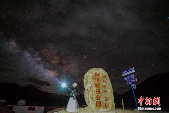 圖為6月20日晚，游客“打卡”西藏阿里暗夜公園，天上是銀河與流星（右上角）。曹枝清 攝