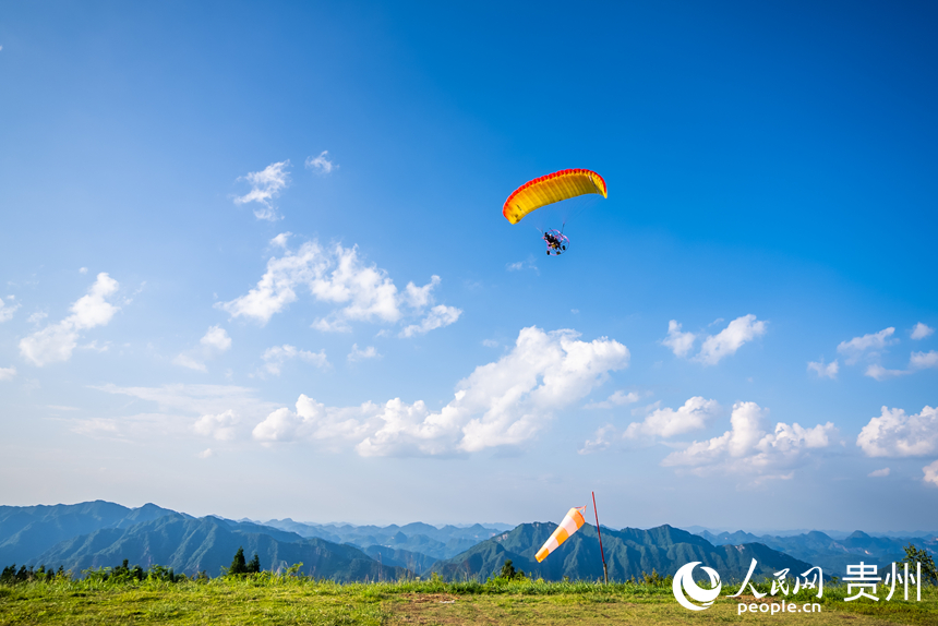 游客在野玉海飛行營(yíng)地乘動(dòng)力滑翔傘體驗(yàn)云端觀景。人民網(wǎng)記者 涂敏攝