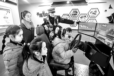 山東省榮成市公安局道路交通安全宣傳教育基地,交警帶領小學生現(xiàn)場體驗模擬駕駛。新華社發(fā)