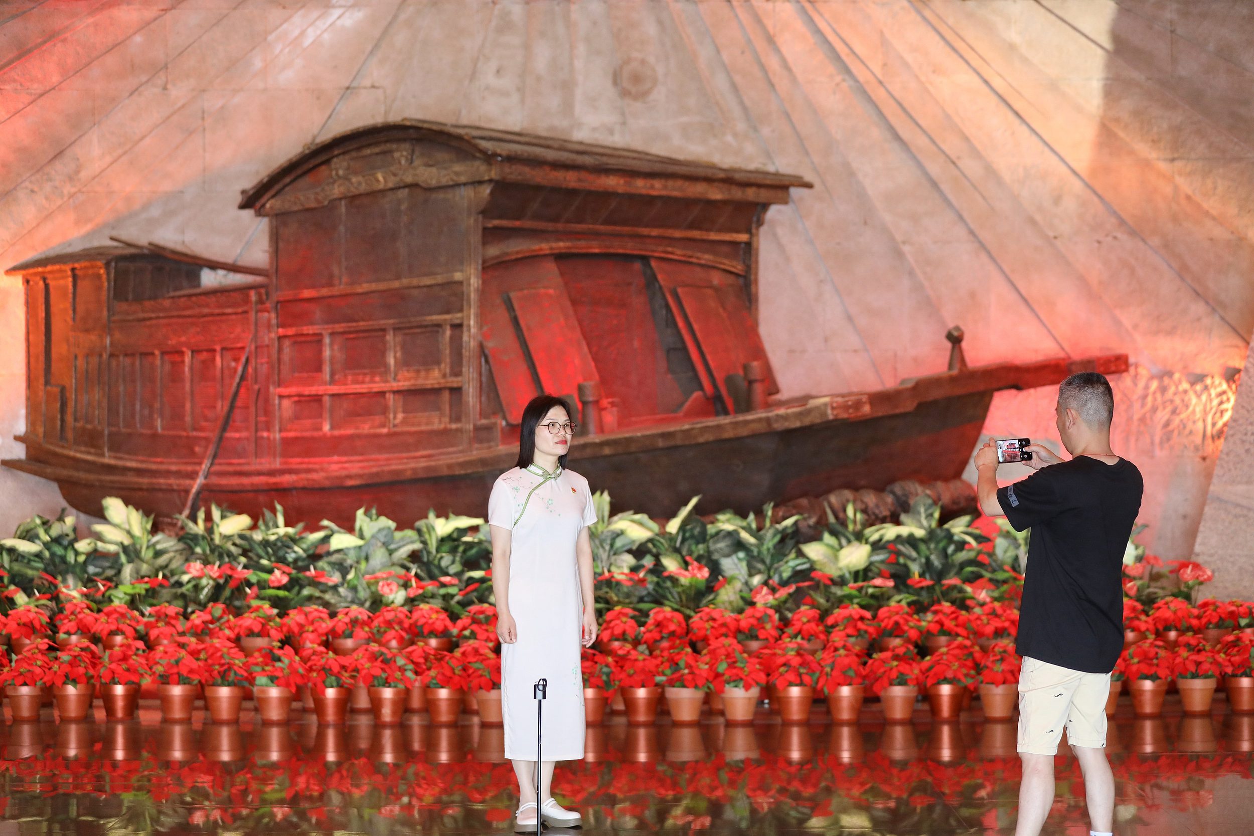 2025年6月24日，浙江嘉興，游客在南湖革命紀念館與紅船雕塑合影。（圖片來源：視覺中國）