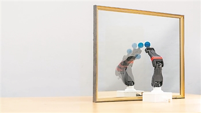  圖為機器人觀察自己在鏡子中的倒影，學習自身的形態(tài)和運動學，實現(xiàn)自主模擬。圖片來源：美國哥倫比亞大學